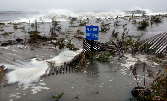 Rough Atlantic surf breaks over the dunes of Cape May, New Jersey, as high tide and Hurricane Sandy begin to arrive, on October 29, 2012. (AP Photo/Mel Evans)