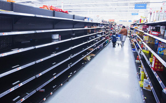 During preparations for Hurricane Sandy, a woman and child walk through an emptied aisle in a Wal-Mart store in Riverhead, New York, on October 28, 2012.