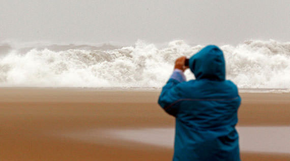 A woman photographs waves from the Atlantic Ocean in Ocean City, Maryland, on October 28, 2012. (Reuters/Kevin Lamarque)